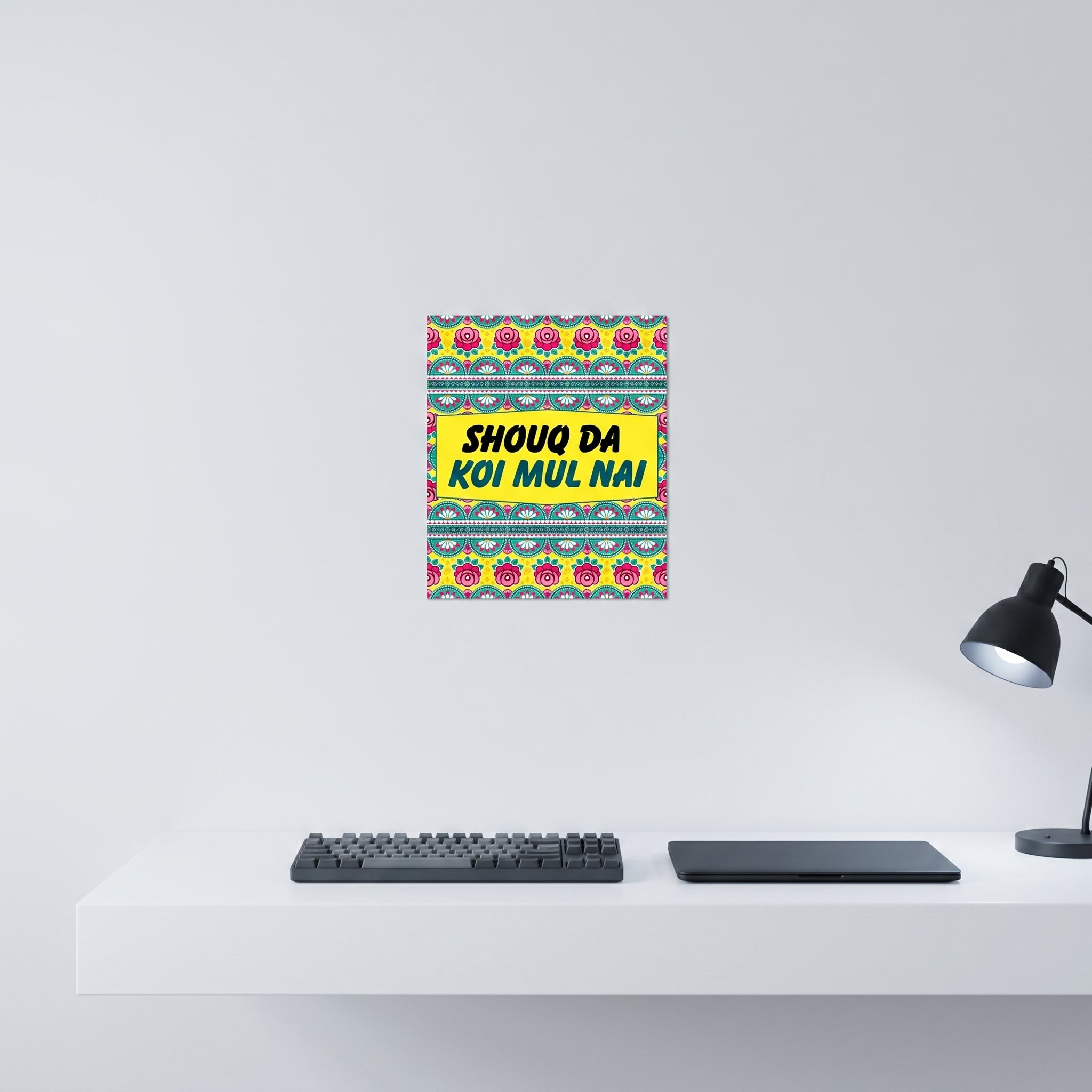 Humorous Punjabi slogan aluminum wall art displayed on a crisp white wall behind a minimalist home office desk workspace setup.

