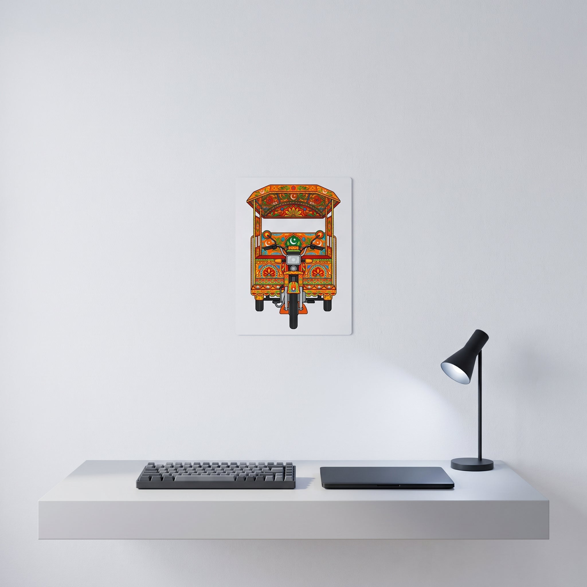Vibrant Pakistani folk art statement sign styled on a crisp white wall behind a minimalist home office desk setup with a keyboard.