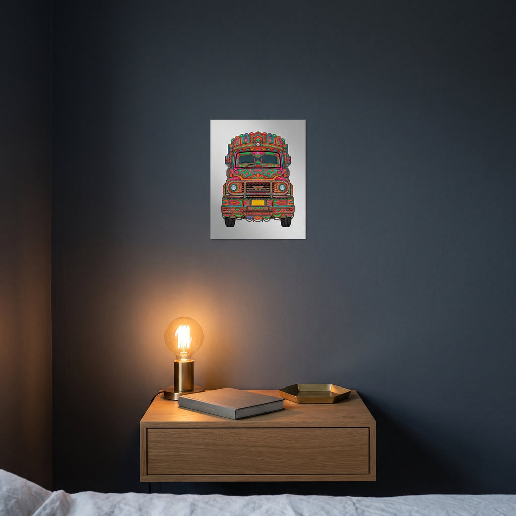 Pop-art style Pakistani heritage metal print catching warm ambient light from a lamp on a contemporary dark bedroom nightstand.
