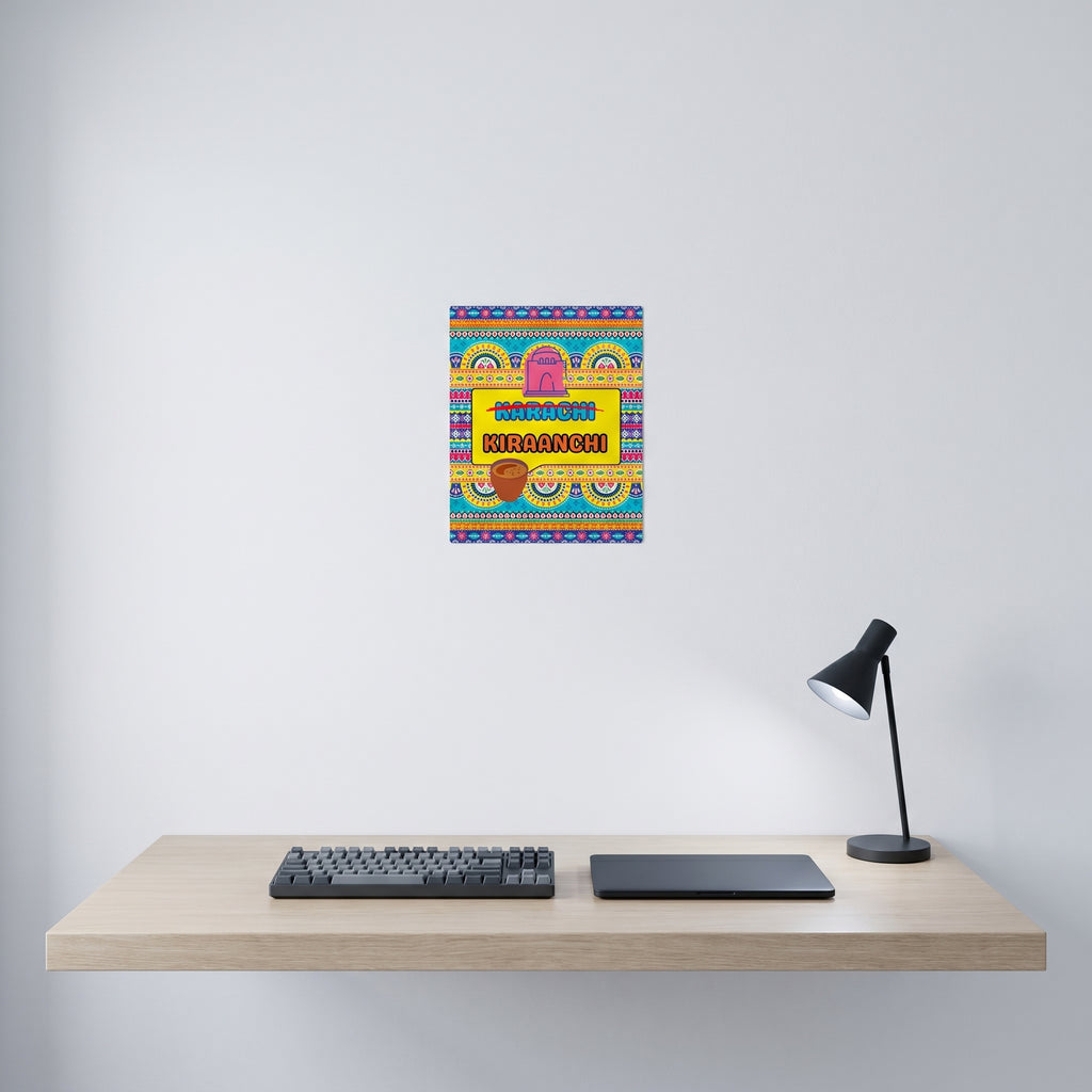 Traditional style Pakistani cultural slogan art print displayed on a crisp white wall behind a minimalist home office desk setup.
