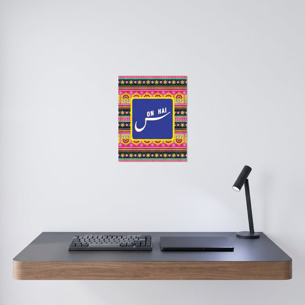Traditional style South Asian pop culture poster displayed on a crisp white wall behind a minimalist home office desk setup.
