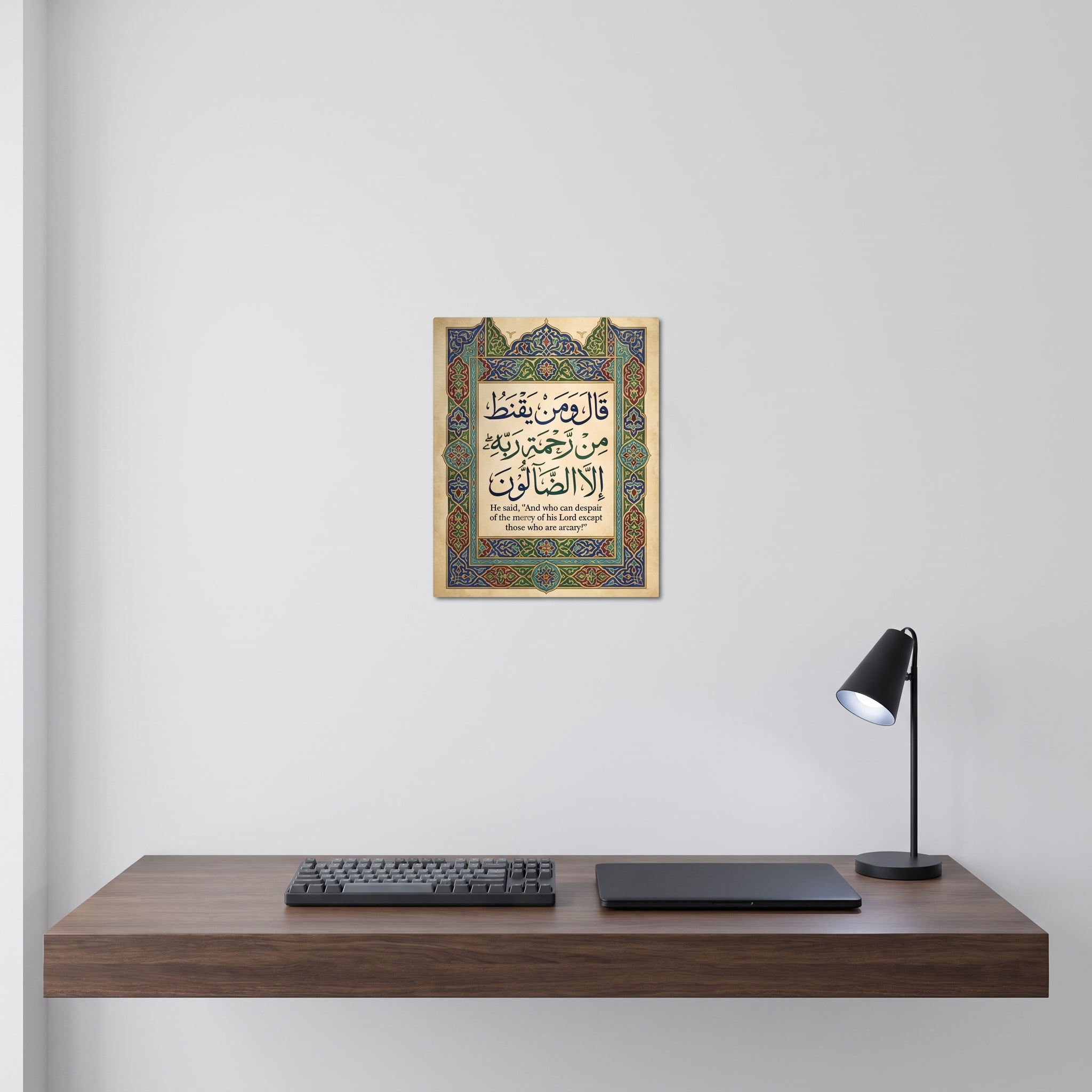 Vibrant Islamic illuminated border statement sign styled on a clean white wall behind a minimalist home office desk setup with a keyboard.